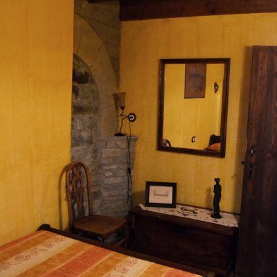 Acogedora habitación con cama de matrimonio, baño compartido y vistas a las calles empedradas del pueblo 